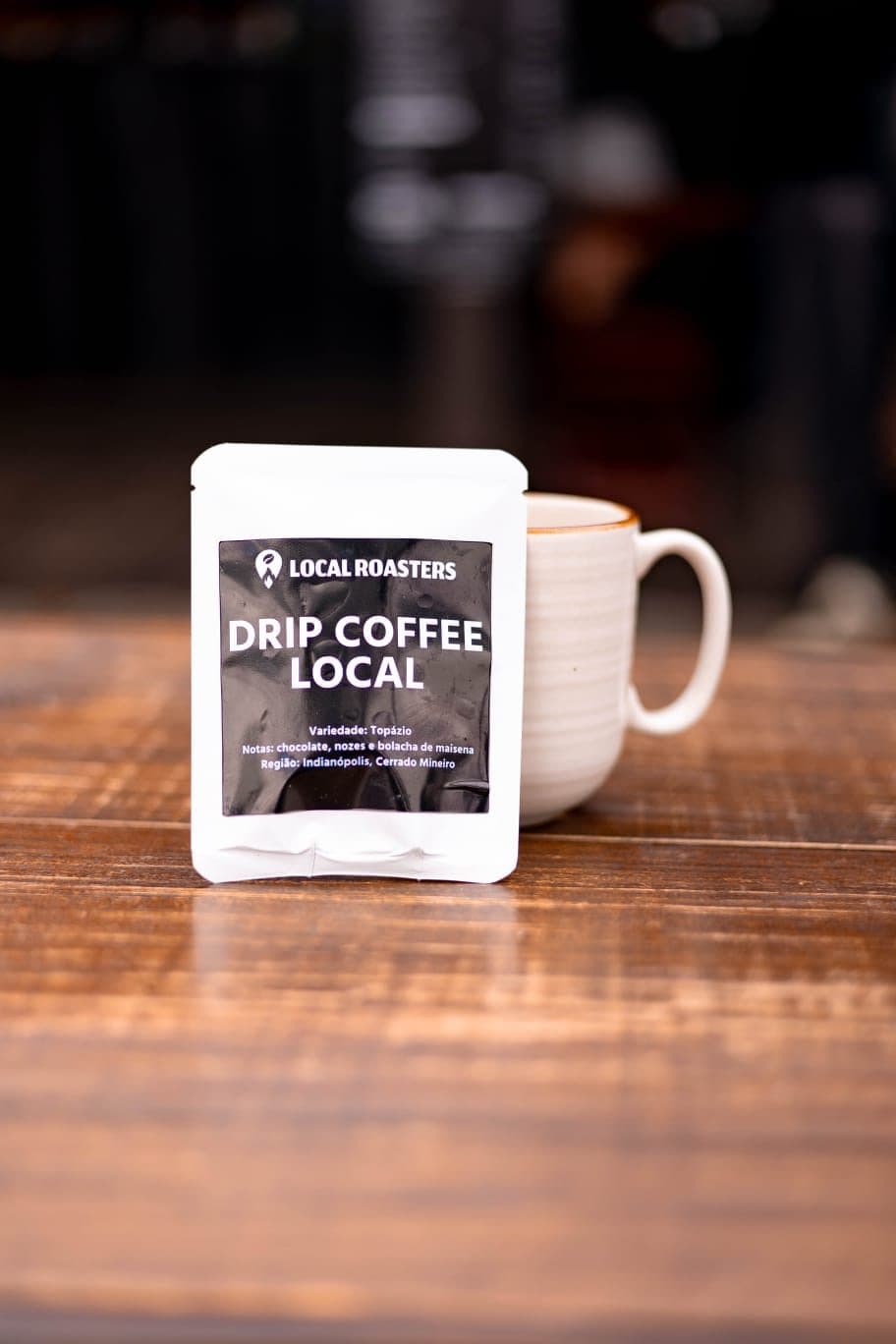 Sachê Drip Coffee Local ao lado de uma caneca